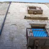 ...con strette finestre ad arco lunato (alcune murate)...